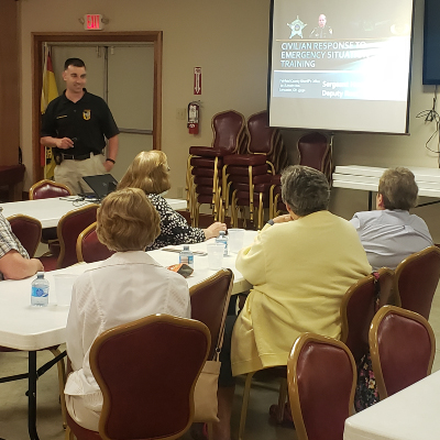 Sgt Hendershot speaking to a group of people sitting down at long tables